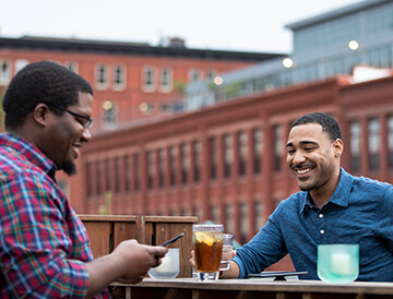 Friends talking about U.S. Cellular referral program on rooftop